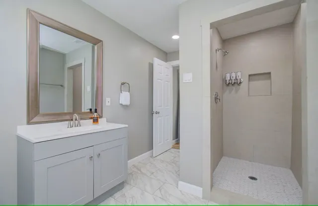 a bathroom with a shower sink and mirror