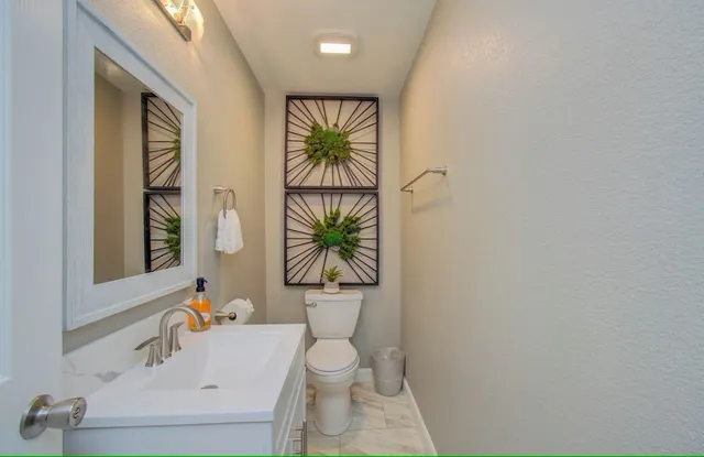 a bathroom with a sink a toilet and a window
