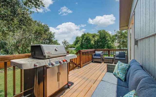 a roof deck with table and chairs a barbeque with wooden floor