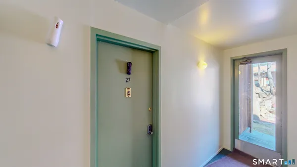 a view of a hallway with wooden floor and stairs