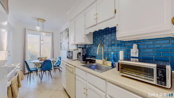 a kitchen that has a lot of cabinets a sink and a window in it