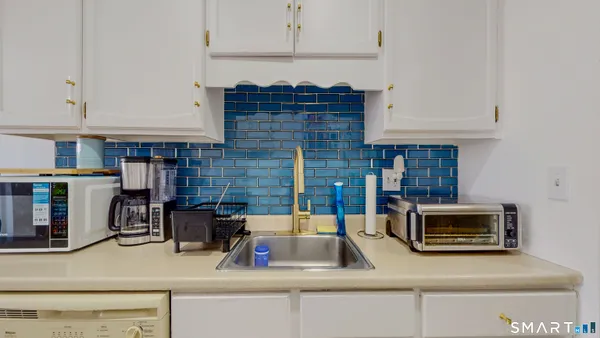 a kitchen with granite countertop white cabinets and white appliances
