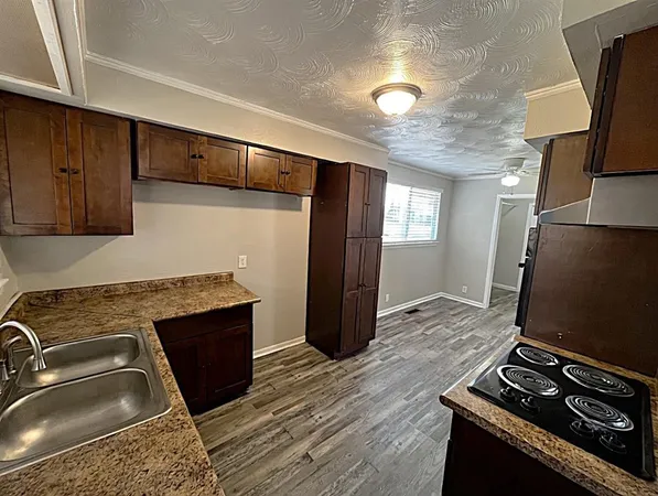 a kitchen with granite countertop a stove and a refrigerator