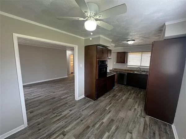 a kitchen with kitchen island wooden floors appliances and cabinets