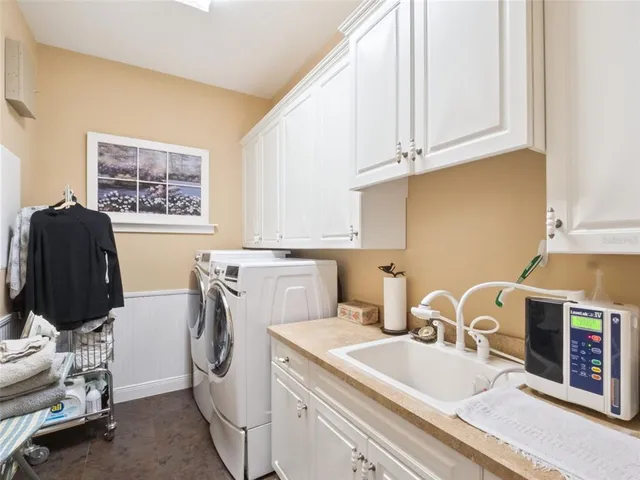 a living room with furniture kitchen view and a large window