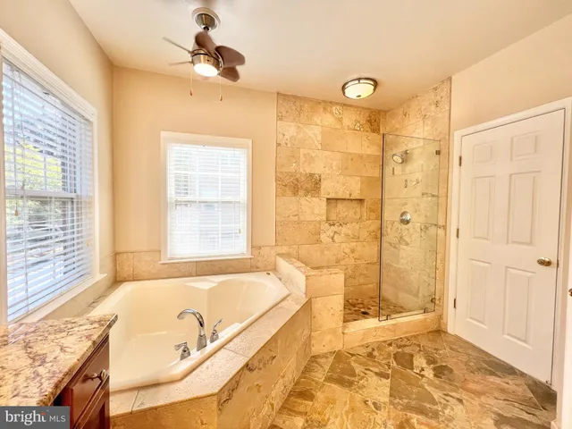 a bathroom with a tub a sink and a shower