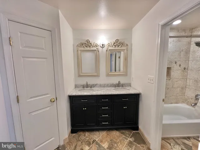 a bathroom with a double vanity sink and mirror with shower