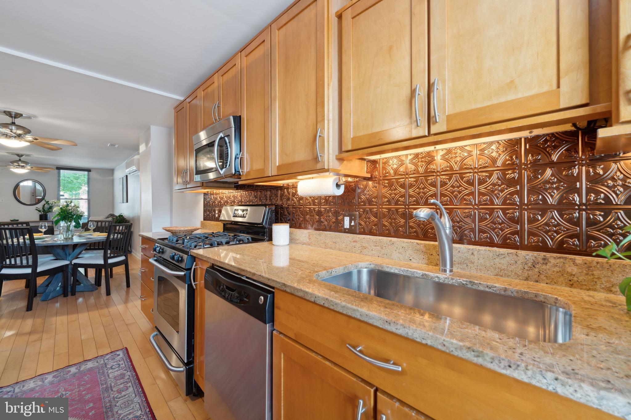 3461 Keswick Road Baltimore, MD 21211 - Photo 16 of 25 a kitchen with stainless steel appliances granite countertop a sink a stove counter space and cabinets