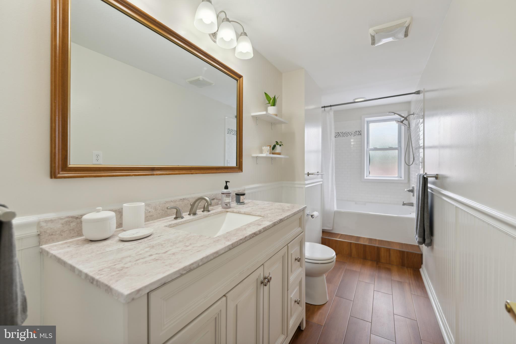 3461 Keswick Road Baltimore, MD 21211 - Photo 21 of 25 a bathroom with a sink a toilet a mirror and shower