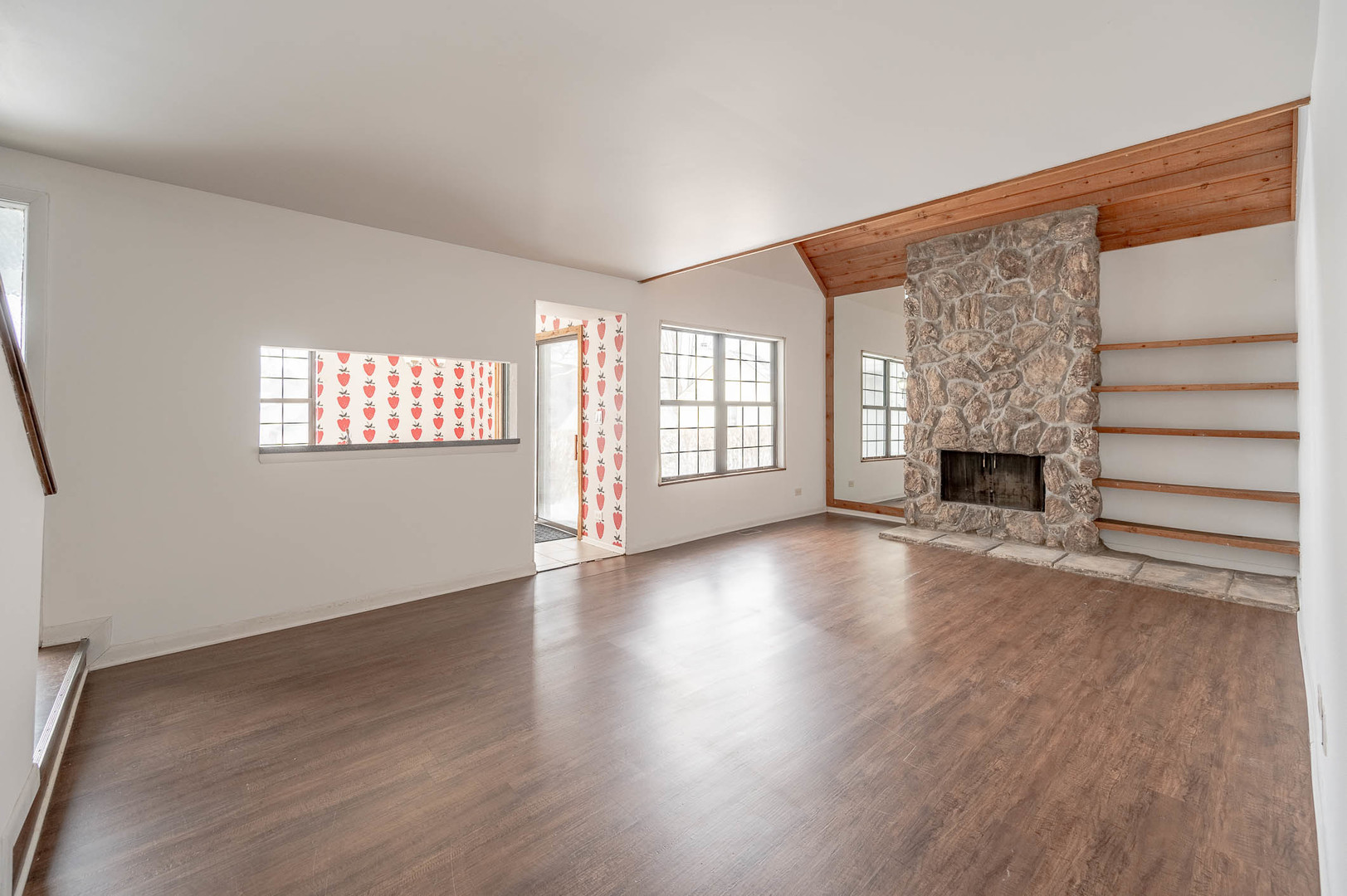 586 Dunham Road Gurnee, IL 60031 - Photo 2 of 13 an empty room with wooden floor fireplace and windows