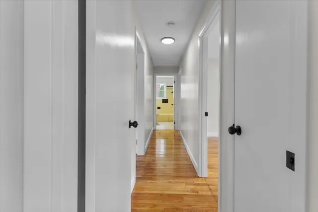 a view of a hallway with wooden floor and staircase