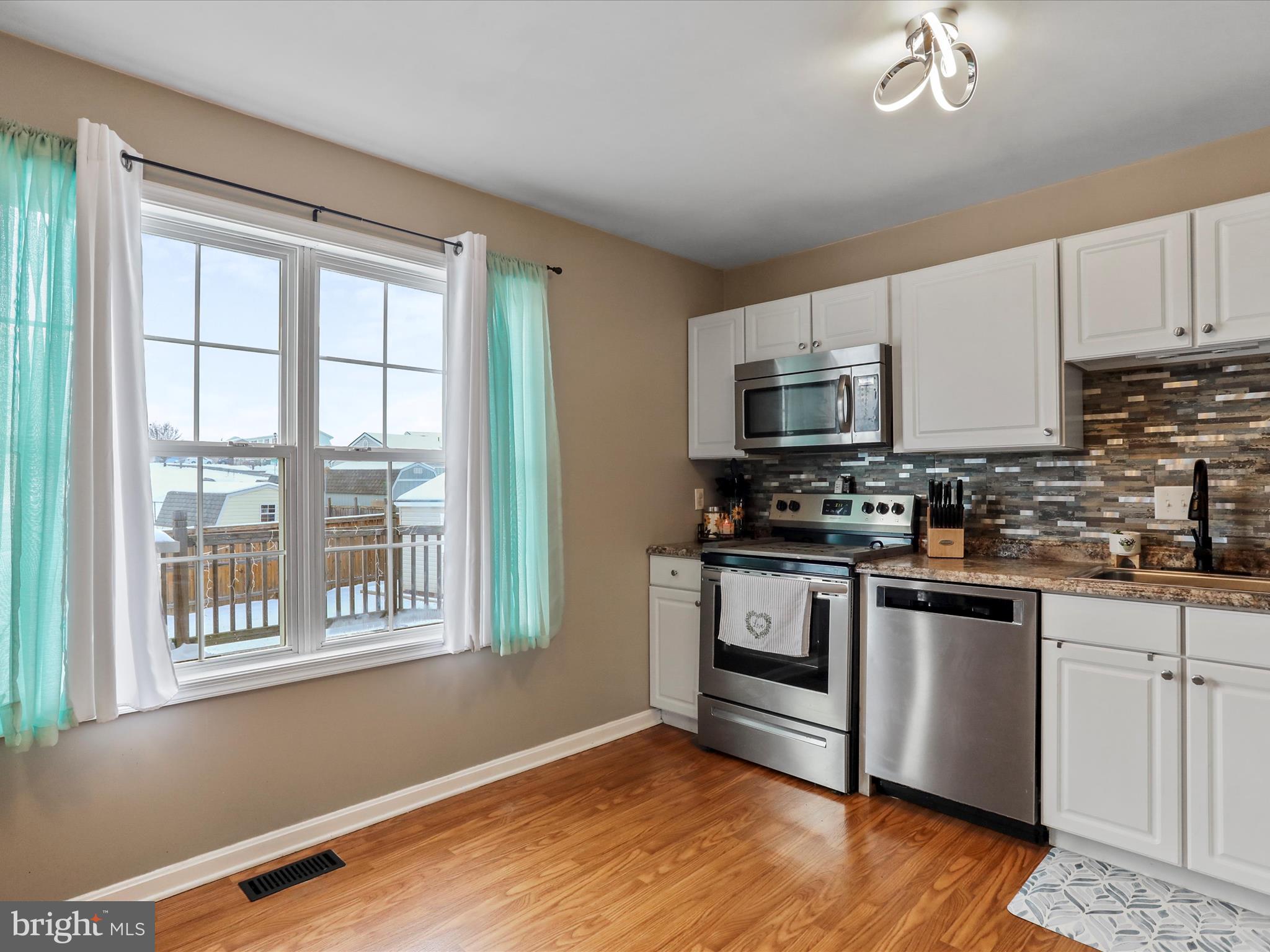 15 Snail Kite Road Martinsburg, WV 25405 - Photo 12 of 37 a kitchen with granite countertop a stove a sink and a microwave