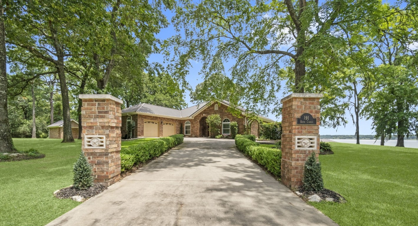 a front view of a house with a yard and trees