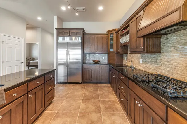 a kitchen with stainless steel appliances granite countertop a refrigerator and a stove