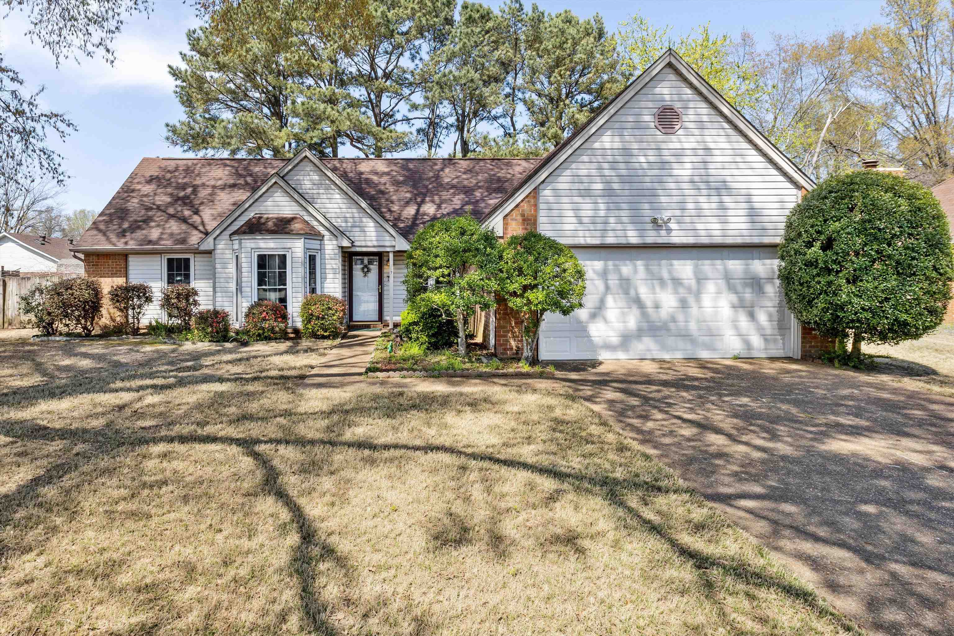 6972 Crestridge Road Memphis, TN 38119 - Photo 1 of 26 View of front of house featuring brick siding, driveway, an attached garage, and a front lawn