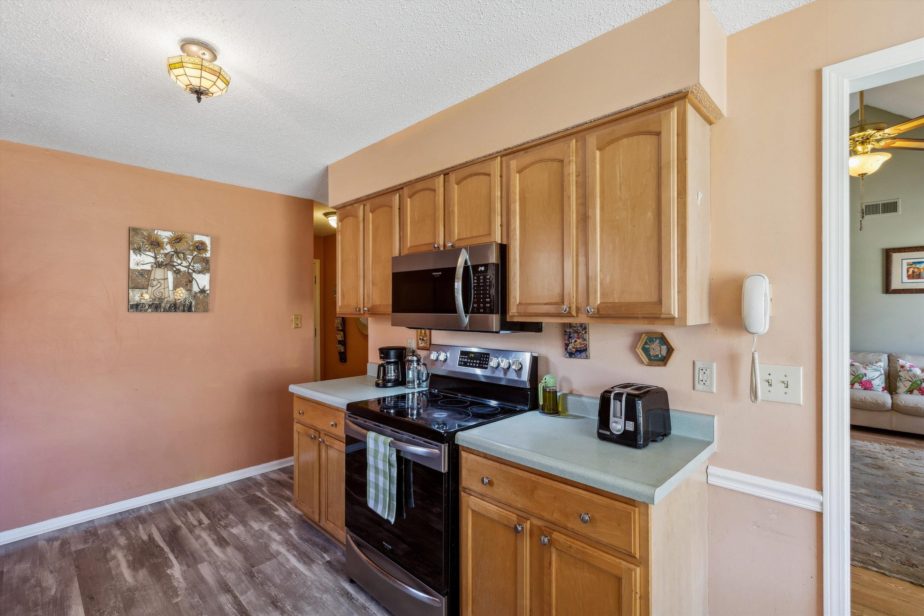 6972 Crestridge Road Memphis, TN 38119 - Photo 12 of 26 Kitchen with dark wood-style flooring, light countertops, visible vents, and appliances with stainless steel finishes