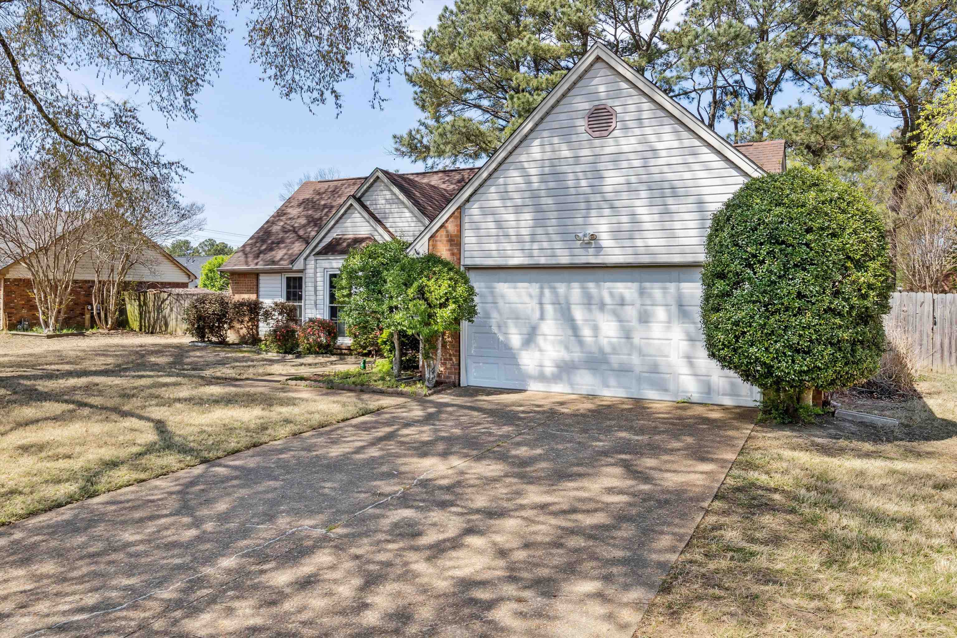 6972 Crestridge Road Memphis, TN 38119 - Photo 2 of 26 View of front of house with a front yard, an attached garage, fence, and concrete driveway