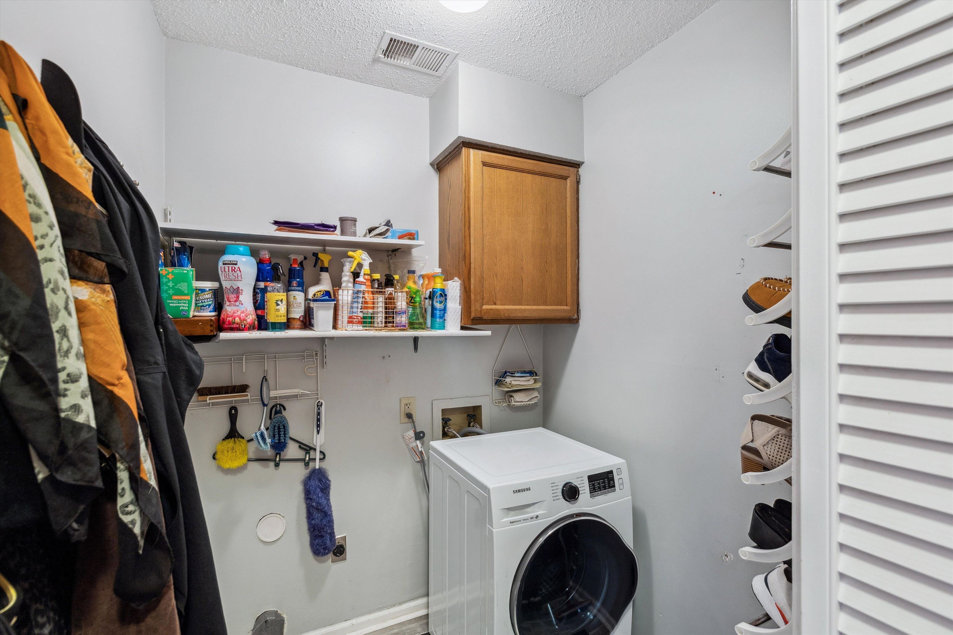 6972 Crestridge Road Memphis, TN 38119 - Photo 23 of 26 Clothes washing area with visible vents, cabinet space, washer / dryer, and a textured ceiling