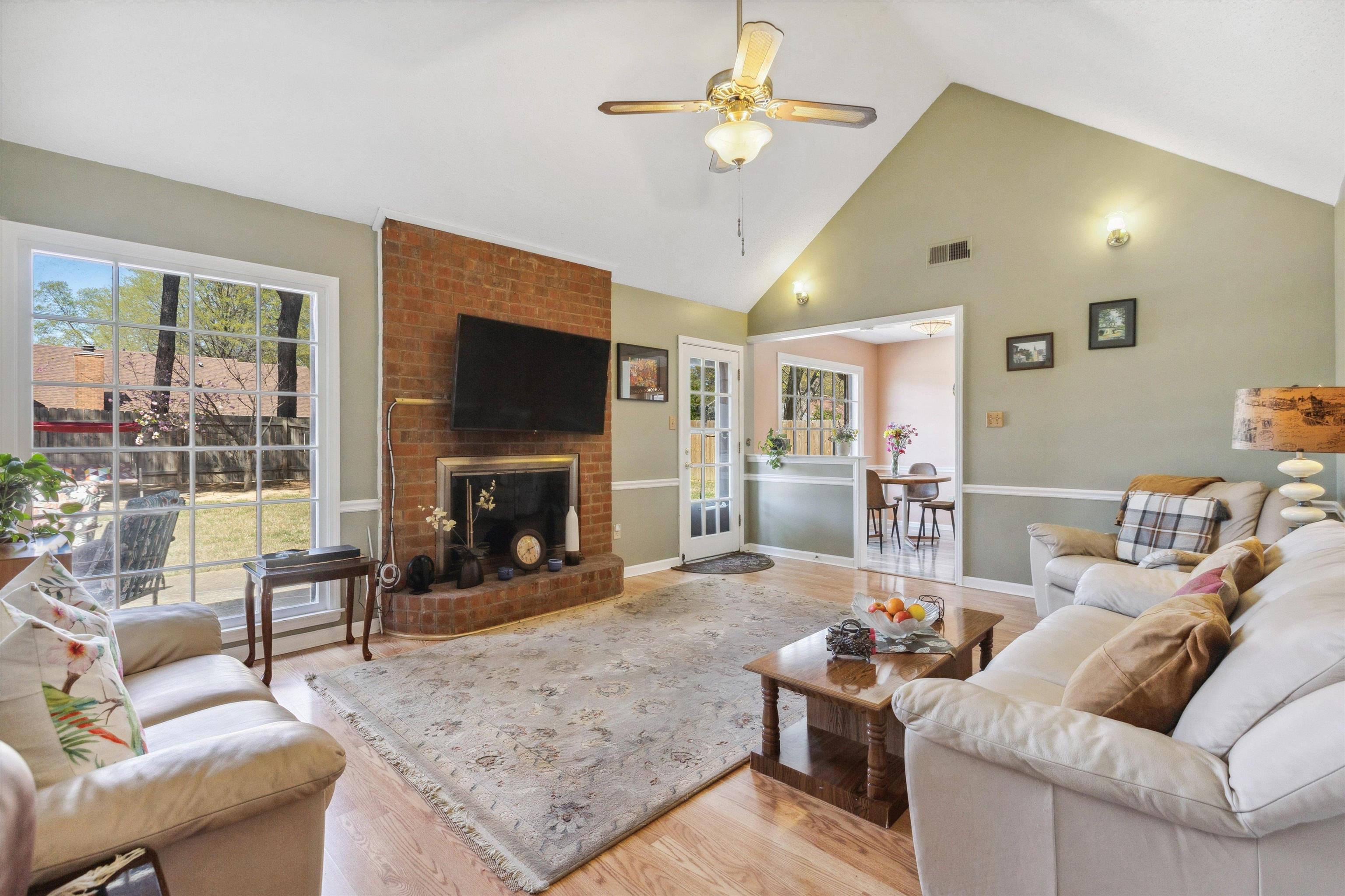 6972 Crestridge Road Memphis, TN 38119 - Photo 8 of 26 Living room with high vaulted ceiling, baseboards, ceiling fan, visible vents, and wood finished floors