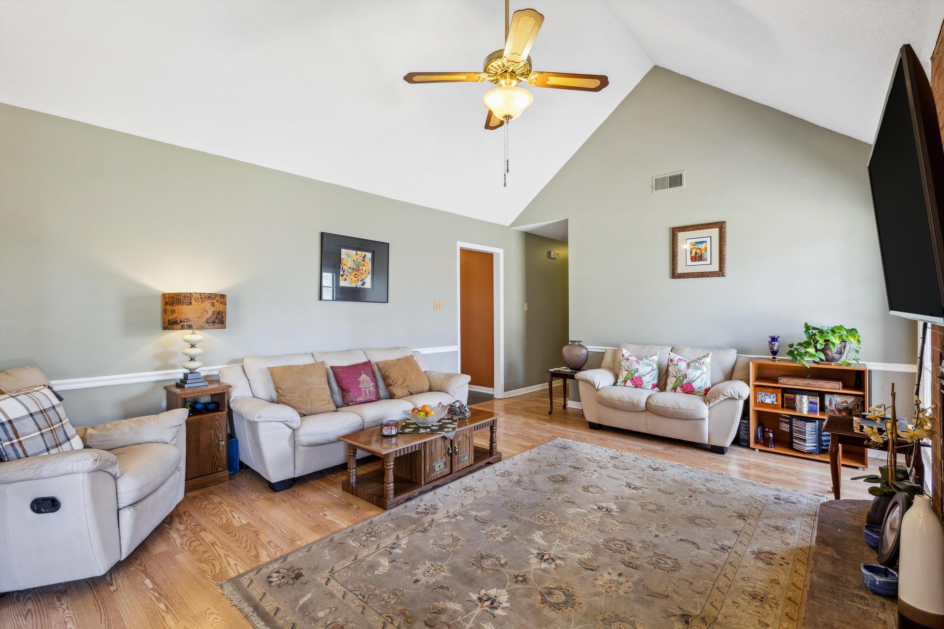 6972 Crestridge Road Memphis, TN 38119 - Photo 9 of 26 Living room featuring visible vents, ceiling fan, wood finished floors, and high vaulted ceiling