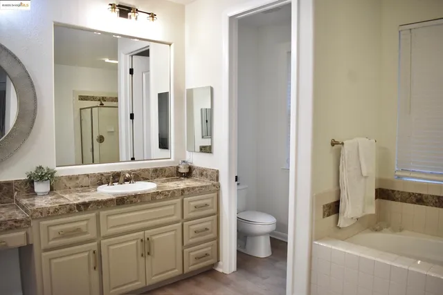 a bathroom with a granite countertop toilet sink and mirror