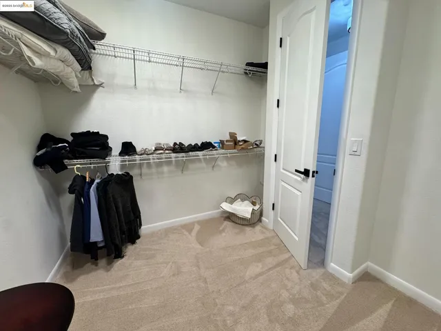 a view of walk in closet with clothes and shoes