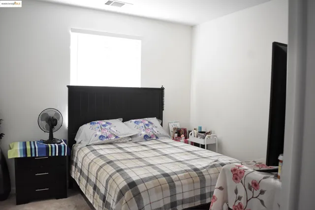 a bedroom with a bed and a potted plant
