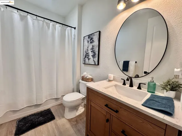 a bathroom with a granite countertop sink mirror vanity and toilet