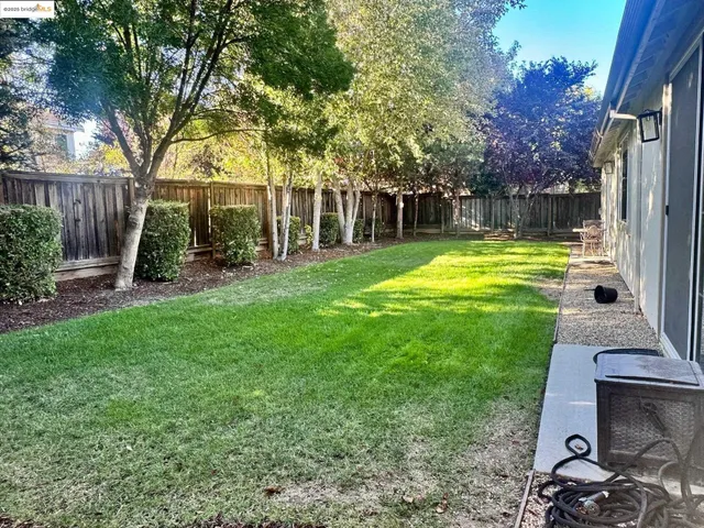 a view of a backyard with table and chairs and wooden fence