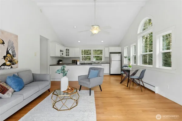 a living room with furniture a dining table and a potted plant