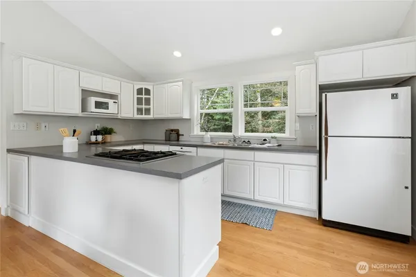 a kitchen with granite countertop a refrigerator a sink and a stove