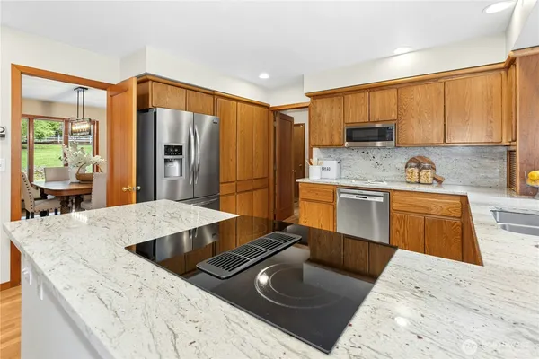 a kitchen with kitchen island granite countertop a sink stove and refrigerator