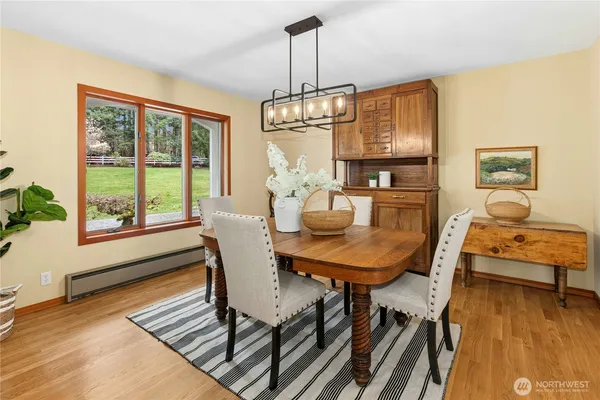 a dining room with furniture a chandelier and wooden floor