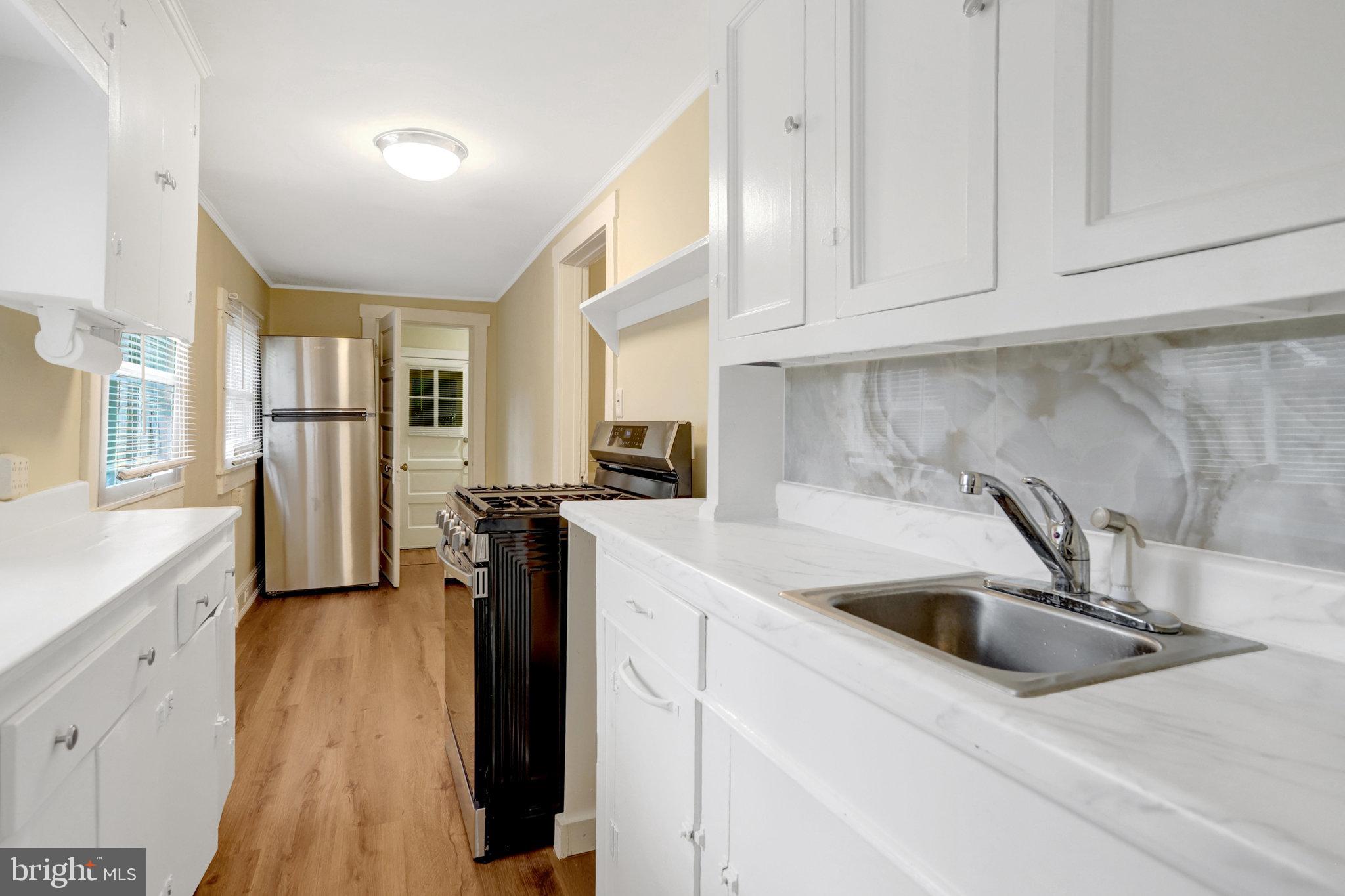 2621 2nd Road North Arlington, VA 22201 - Photo 13 of 44 a kitchen with stainless steel appliances granite countertop a refrigerator a sink a stove and white cabinets with wooden floor