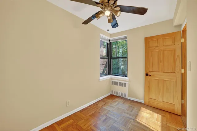 an empty room with a ceiling fan and a window