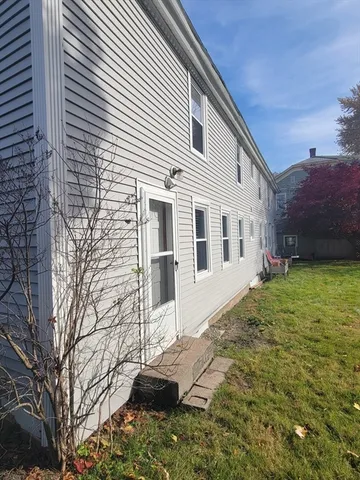 a white house that has tree in front of it