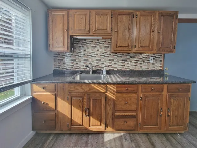 a kitchen with granite countertop white cabinets and sink