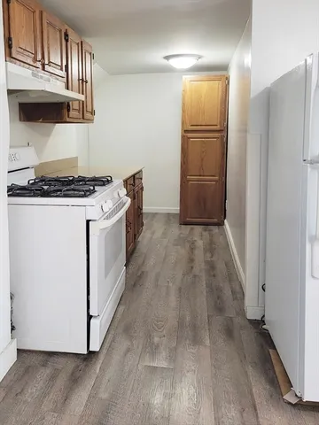 a kitchen with a wooden floor and a stove top oven