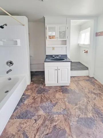 a bathroom with a granite countertop sink a toilet and bathtub
