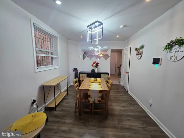 a dining room with wooden floor a chandelier a wooden table and chairs