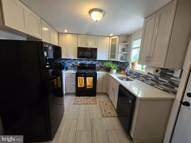 a kitchen with stainless steel appliances a stove a sink dishwasher a refrigerator and a microwave