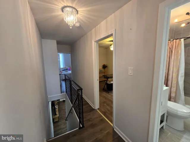 a view of a hallway with workspace and a livingroom with furniture