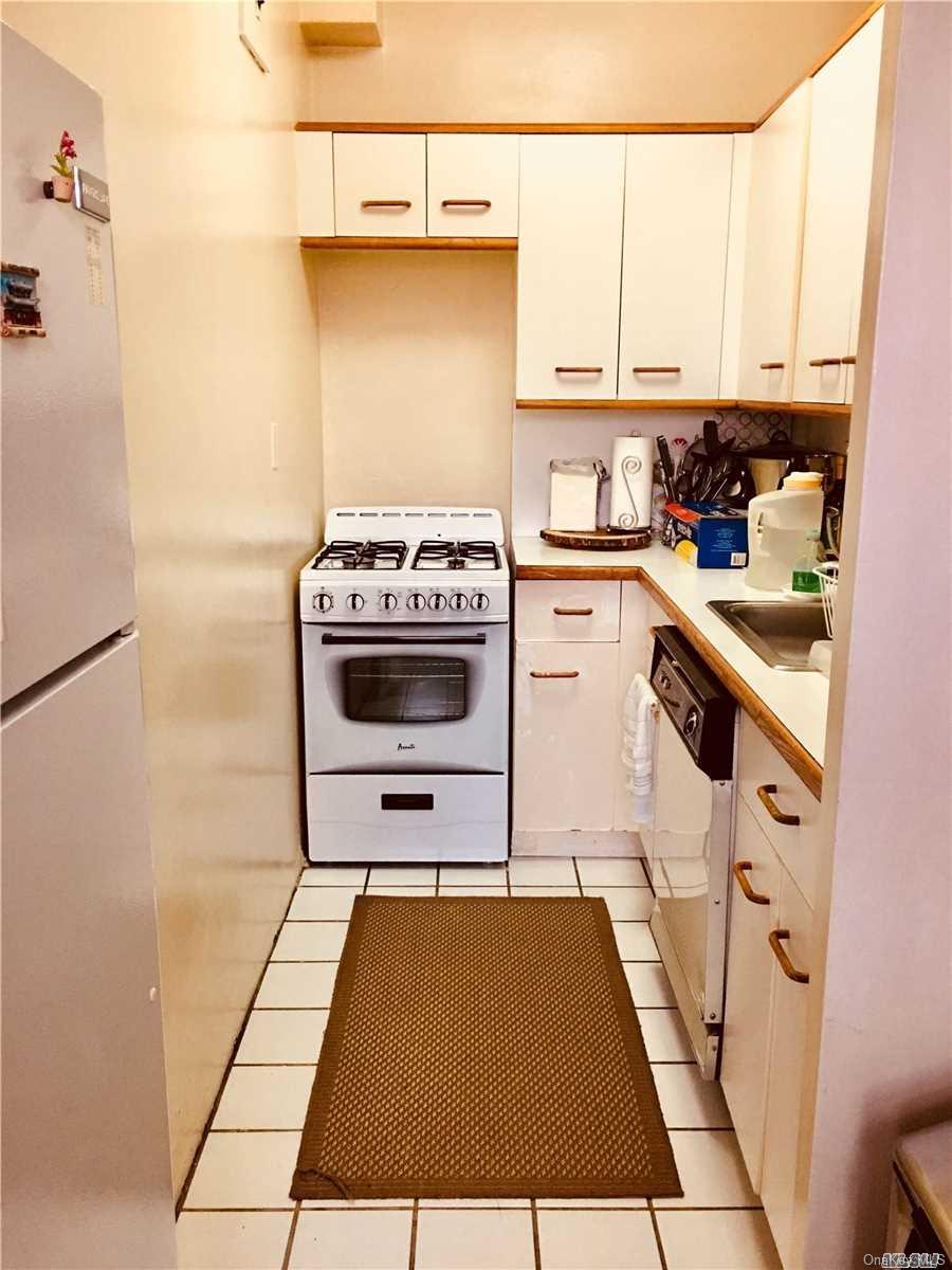 99-72 66th Road, Unit 5F Queens, NY 11374 - Photo 1 of 1 a kitchen with a stove and a refrigerator