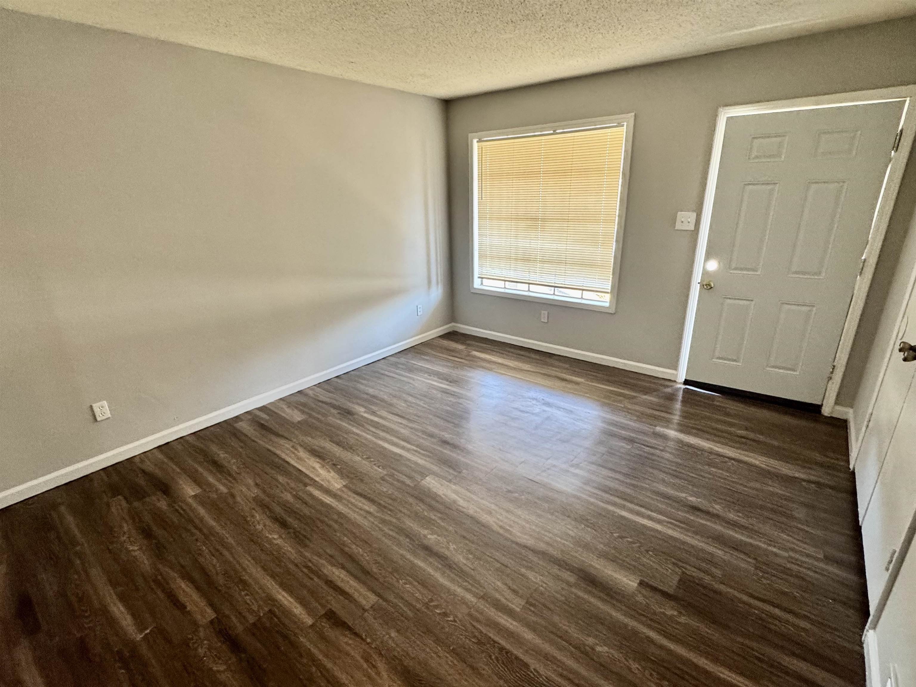 4057 Windermere Road Memphis, TN 38128 - Photo 3 of 14 a view of an empty room with wooden floor and a window