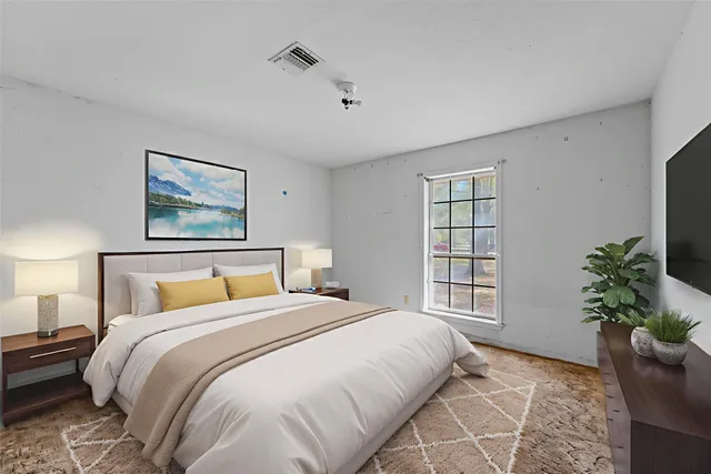 a bedroom with a large bed and a potted plant