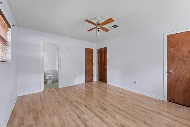 a view of a livingroom with wooden floor and a ceiling fan