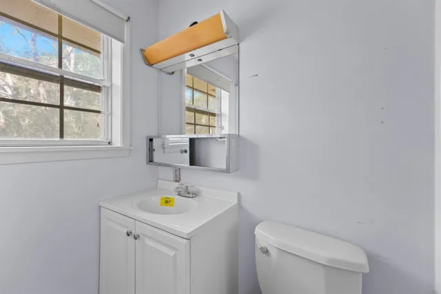 a bathroom with a toilet sink and mirror