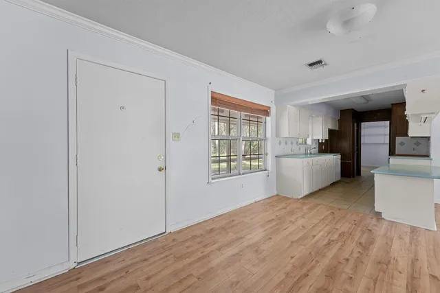 a view of a kitchen with wooden floor and electronic appliances