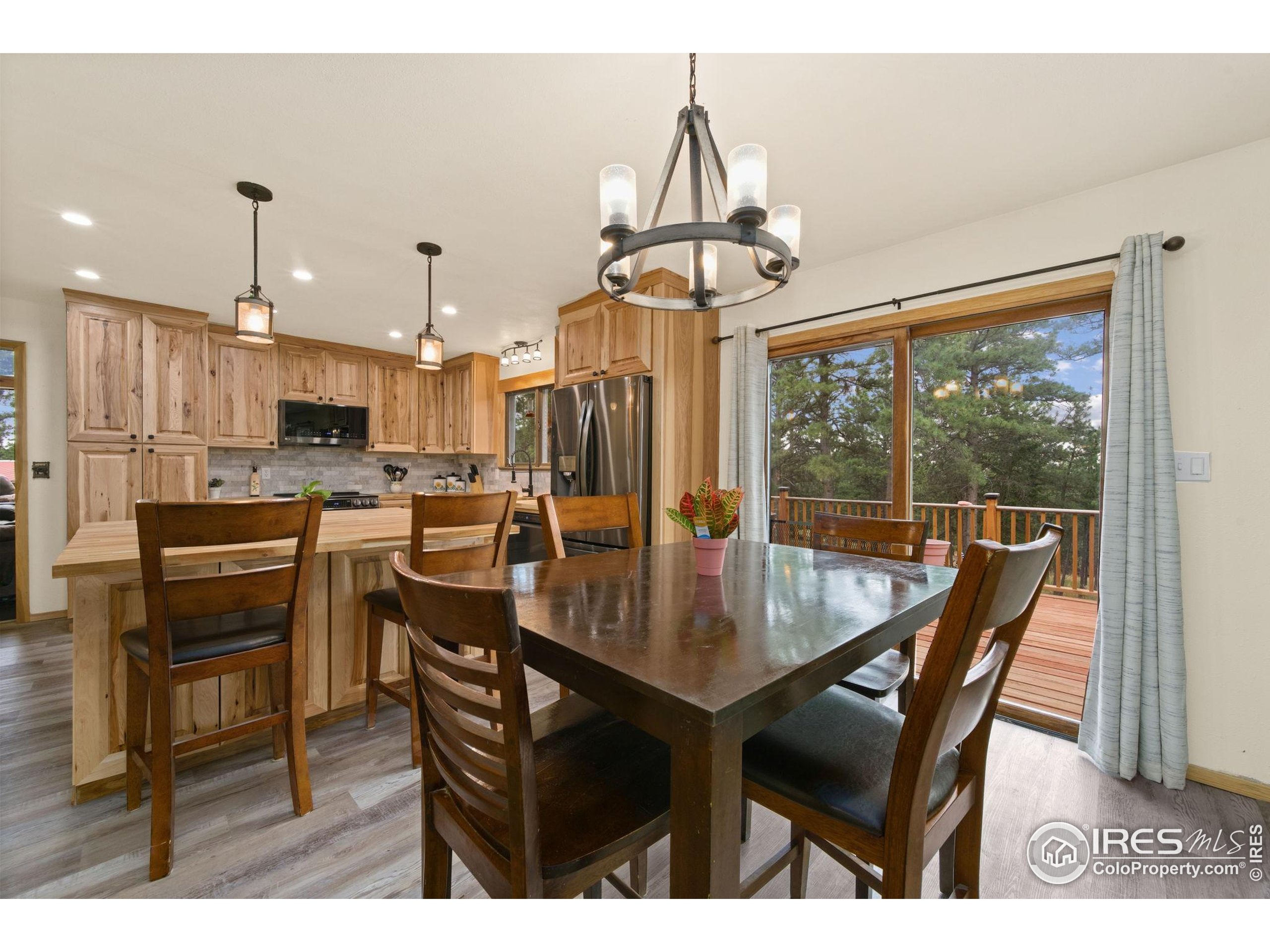 269 Cox Court Bellvue, CO 80512 - Photo 11 of 47 a dining room with furniture a chandelier and wooden floor