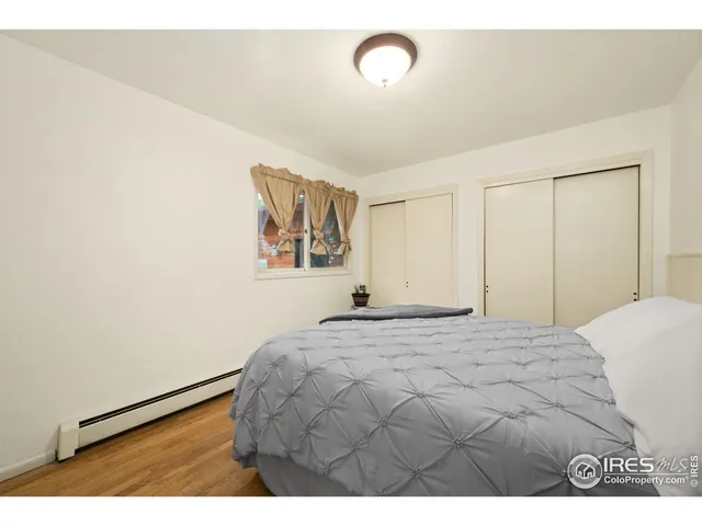 a bedroom with a bed and a painting on the wall